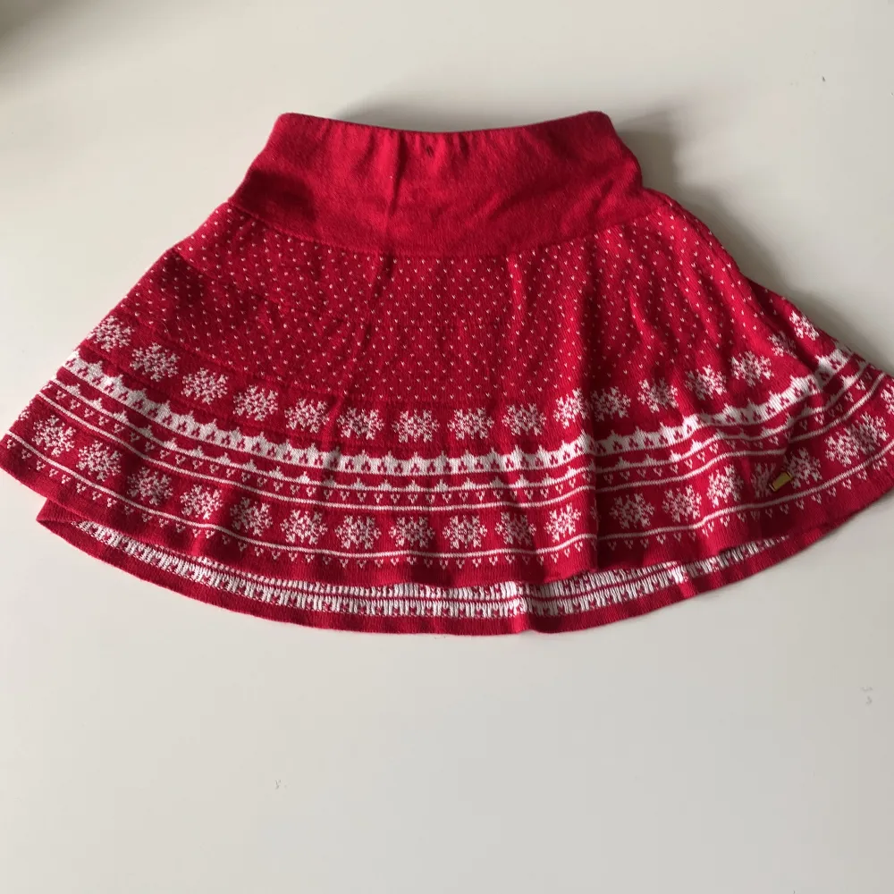 Röd-vit stickad kjol, perfekt till juloutfiten. Slutar strax ovanför knät. Använd ett fåtal gånger. Kjolar.