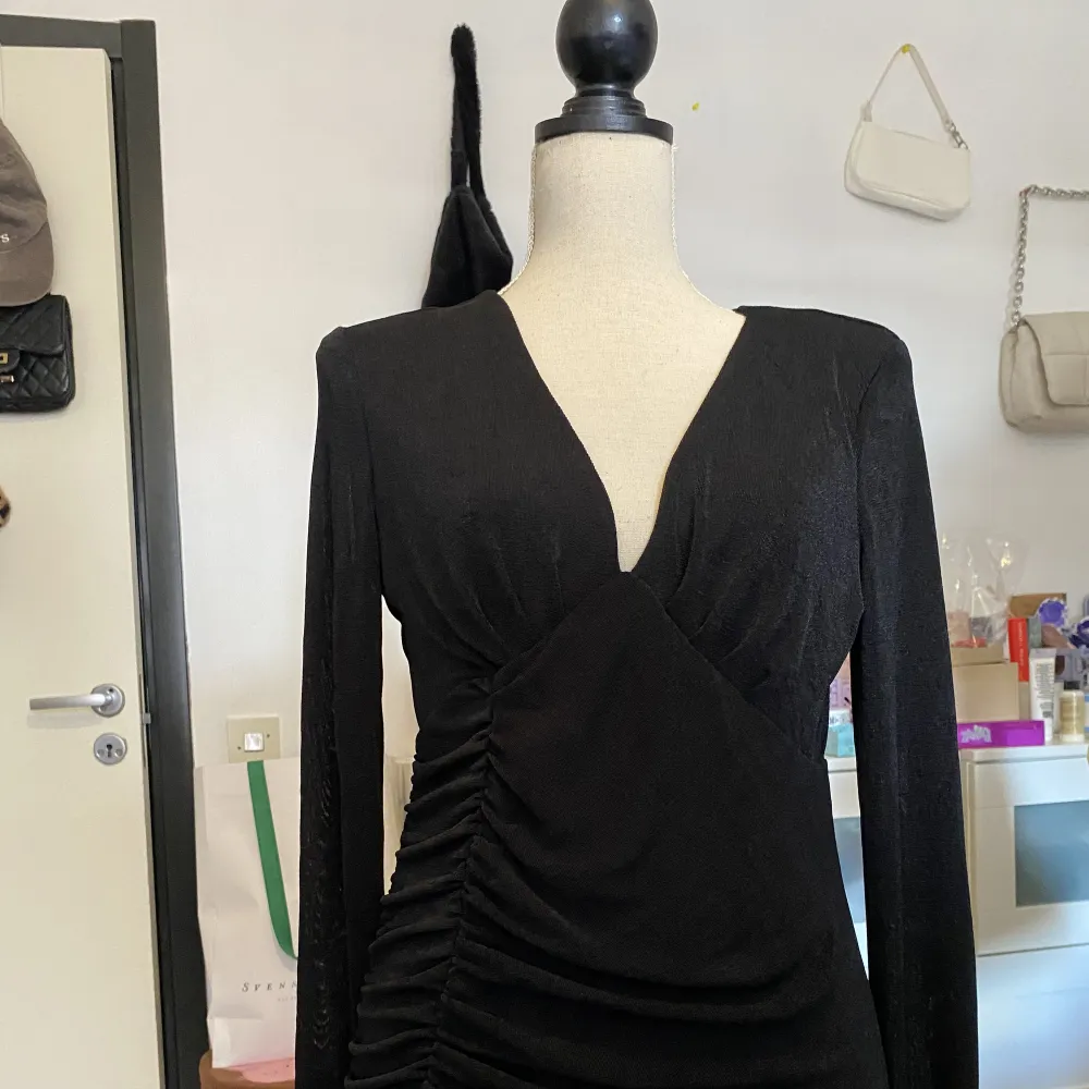 Glittrig svart fest/aftonklänning med snygg rouching på sidan och slit. Aldrig använd och i helt nytt skick. Klänningar.