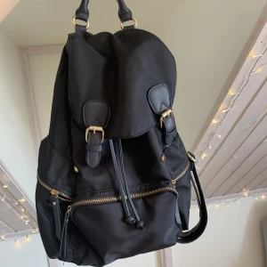 Ryggsäck med gulddetaljer  - Gullig ryggsäck som tyvärr inte kommer till användning längre. Den är använd men i gott skick och har bra fickor och annat för att ha saker i.😊