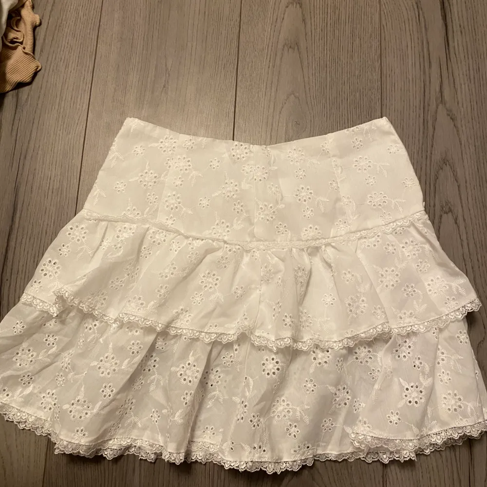 Säljer den här vita kjolen med ett blommigt hål-mönster från Shein. Den har storleken M (alltså 38) men är liten i storleken! Lapparna sitter kvar!💕 Skriv om ni har några frågor🩷. Kjolar.