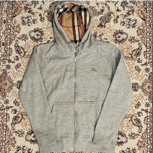 Burrberry hoodie zip - Säljer denna fina burrberry kofta i zip modellen❤️herr storlek och är i storlek M. Jätte skön snygg och bekväm men kommer aldrig till användning längre, lite trög dragkedja men olja den så är den som den ska!