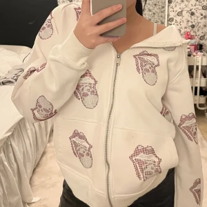 Rhinestone hoodie  - Säljer min poisoned love rhinestone zip up hoodie! Har haft på mig den ett par gånger. Den har en liten fläck på ena fickan (se sista bilden).  Hoodien är mjuk och tjock och är gjord på 100% bomull. Storlek S.   Nypris: 950kr. Frakt tillkommer! 🌸