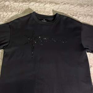 En svart rhinestone t-shirt från märket unkown london. Tröjan har använts kanske 2-3 gånger.  Storlek: Medium