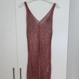 Rosaglittrig klänning  - En rosa klänning i ett nät material som är glittrig och passar till fest eller att ha på stranden över en bikini 👙