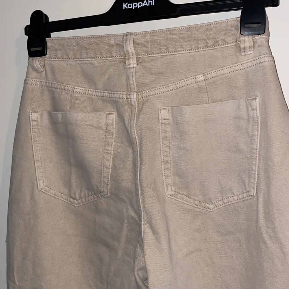 Beiga jeans från Bershka, wide leg med slitningar på knäna. Storlek 38 men liten i storleken . Jeans & Byxor.