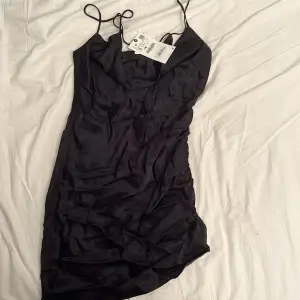 Svart silkes klänning från Zara helt oanvänd med lapp kvar! (org. pris 359kr) Är skrynklig då jag haft den i förvaring, men en av sidorna är sydd i designen så att den ska va lite snyggt skrynkligt och lite ossymetrisk!🫶