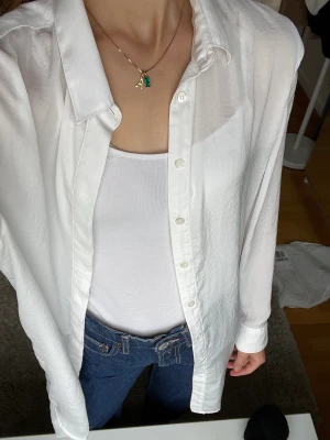 Lång vit sommarblus! - Lång vit blus från Crocker. Jag är 170 lång och blusen går ner till halva låren ungefär😁 Tunn och väldigt skön till sommaren. Går även att bära som en skjortklänning. Något genomskinlig. Storlek M, men passar även XS/S, beroende på önskad passform😊