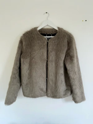 Grå kort fuskpäls jacka  - En fin grå fuskpäls i grått. Storlek Small. 