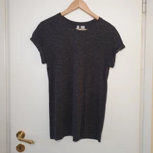 T-shirt  - Mörkgrå mellerad basic T-shirt, med uppvikta armar.