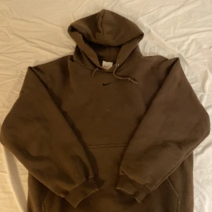 Vintage Nike Hoodie - Brun oversized Nike hoodie i storlek M. Hoodien har en liten orange fläck vid mitten men inget som syns så tydligt då hoodien också är brun. 