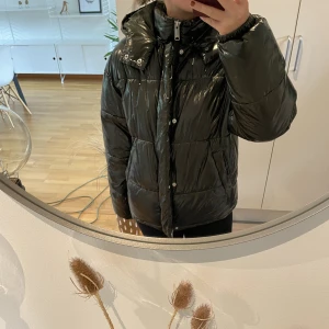 Pufferjacket - Säljer nu denna pufferjackan som tyvärr inte kommer till användning längre. Jackan är i mycket gott skick (som ny). Material: lackliknande som tål vatten bra!