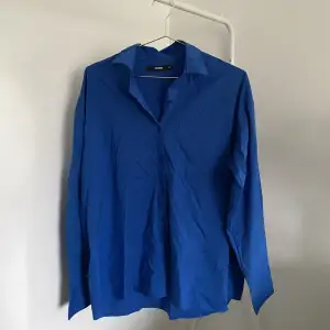 En blå skjorta från BikBok. Storlek S. 