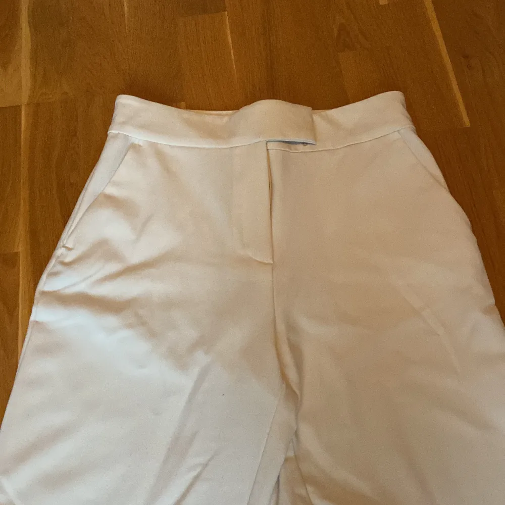 Ett par vita kostymbyxor i storlek 38. Highwaist och straight. Superskönt material och aldrig använda. Typ beige/vit. Skriv om ni har frågor.. Jeans & Byxor.