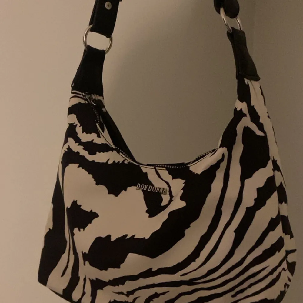 Don Donna zebra-print bag, använd fåtal gånger och i nyskick. Bra fest-väska och helt slutsåld, köpt för 599kr skriv för fler frågor🤩. Väskor.