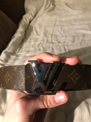 Louis Vuitton Bälte strl 90 - Säljer mitt LV-bälte som jag fick i julklapp. Så gott som nyskick förutom en repa på spännet som inte riktigt ses på bilden, därav priset. Låda och påse fås med.  Modell: LV Initials 40mm Reversible Nypris: 5300kr