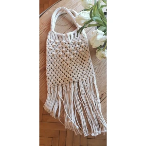Väska i makramé med snäckskal - Bohemisk axelväska/shopper med fransar. 100% bomull. Oanvänd. A4-storlek. Man får plats med nåt platt som är 35 cm högt och 27 cm brett.