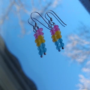 Örhängena - Ett par oanvända örhängen med🩷💛🩵pärlor på, pris kan diskuteras☁️medföljer en liten fin påse med🌱