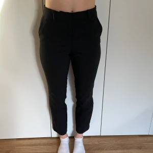 Svarta ankelhöga kostymbyxor. - rta ankelhöga kostymbyxor. Storlek 36. HM. Modellen bär vanligtvis storlek 36 och är 168cm lång. Väldigt bra skick! 