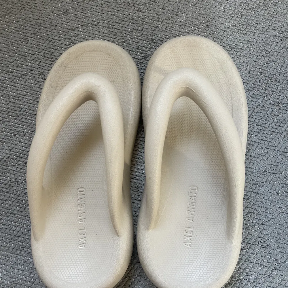 Flip flops från Axel Arigato. Endast använt 2-3 gånger. Nypris 1300 Vit/beiga. Skor.