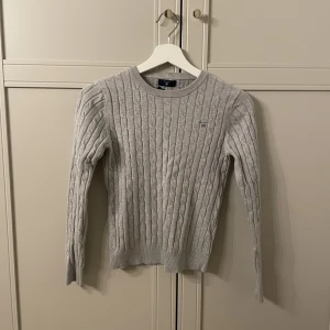 Stickad tröja från Gant - Grå superfin kabelstickad tröja från Gant. Storlek xs och i bra skick💗100kr+frakt💗pris går alltid att diskutera! Skriv för fler frågor