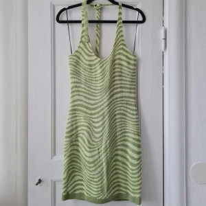 Klänning - Stickad miniklänning i snyggt mönster och band som kan knytas på olika sätt. Är endast provad. Är från H&M och prislapp sitter kvar. Nypris 199 kr