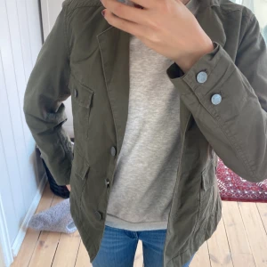 Vårjacka  - En militär grön vårjacka i storlek 34 men som är som 32 eller XS. Jätte bra skick.