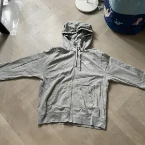 En grå nike zip hoodie med vit logga. Hoodien är i bra skick och storlek M tts. Priset kan justeras.🙌