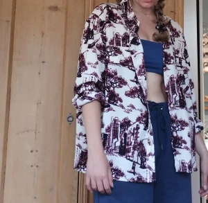 Skjorta - Lindex skjorta med människo, natur och hus motiv på. Polyester 