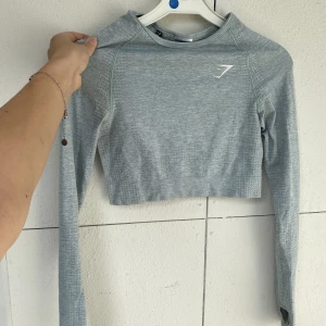 Gymshark Grå/Blå träningströja - På bilden ser den väldigt grå ut men är mer ljusblå i dagsljus. Säljer då den inte kommit till användning 