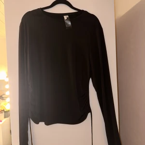 Öppen rygg tröja - En svart lång armar topp med öppen rygg med en knyte ned till från Nelly i storlek XL, i nyskick🖤
