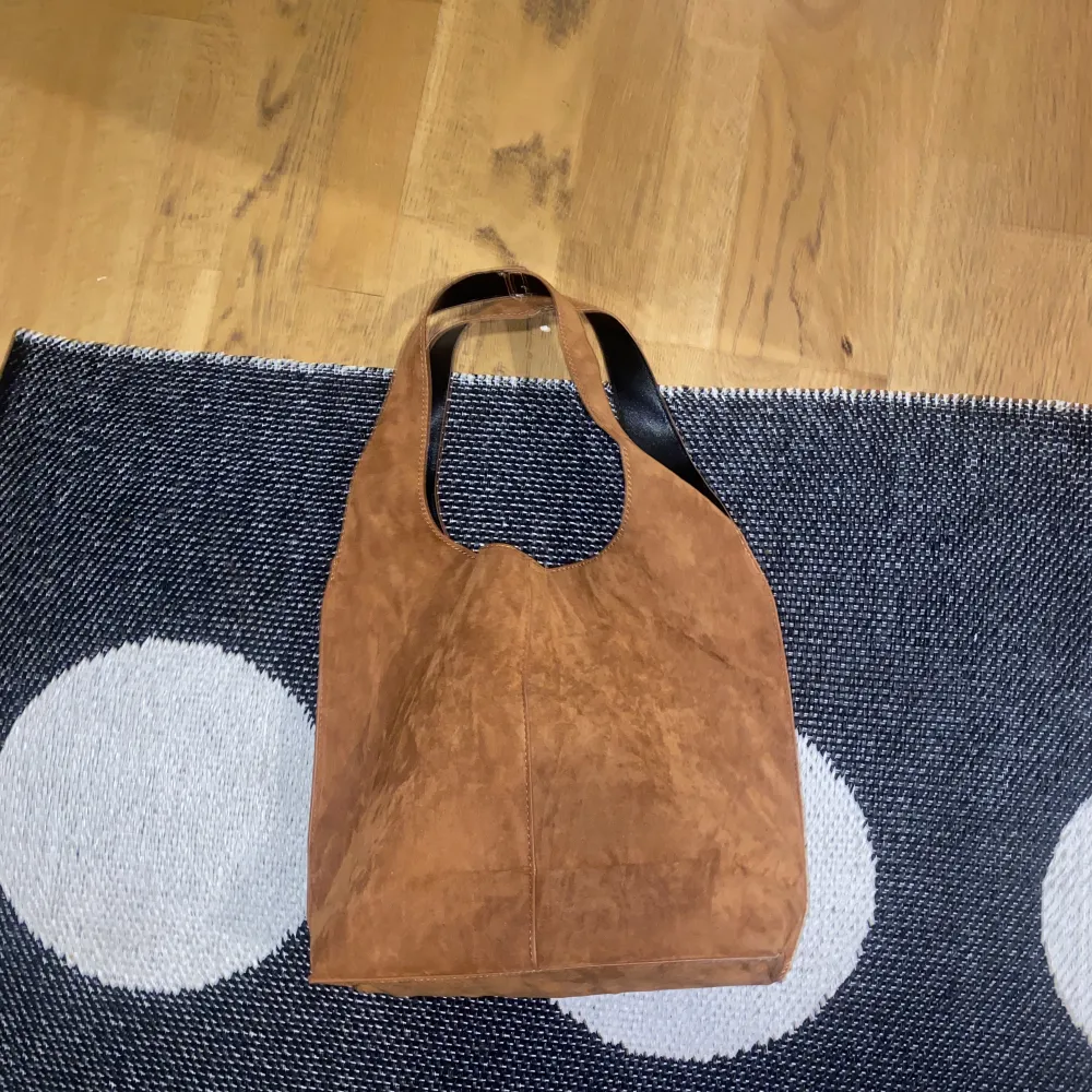 Säljer denna bruna väskan, nästan aldrig använd!! Rymmer ganska mycket, finns en knapp så den inte är så öppen. . Väskor.