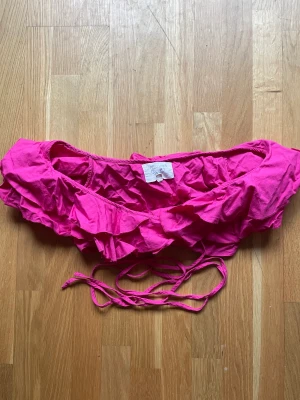 Knyttopp kort - Knyttopp med volanger som sitter vid axlarna. Kort och knyta omlott. Använd. Ej stretch. 