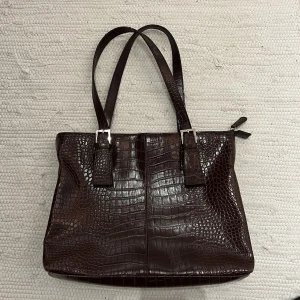 Brun vintage väska - Köpt secondhand i mörkbrunt! Min 13tum dator får plats i den!