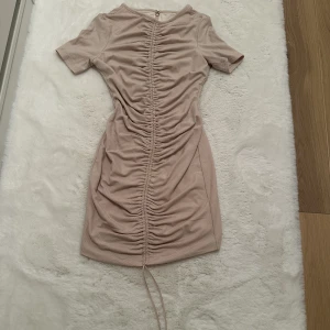 Miniklänning från meshki - Storlek M men passar även som XS/S  Materialet är stretchtyg och sitter tight på kroppen, justeras med snören på framsidan  