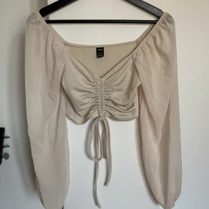 Långärmad tröja - Aldrig använd. Justerbar framtill. Genomskinliga ärmar. 