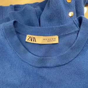 Säljer denna slutsålda tröja från zara. Den är blå med guld nitar. Endast använd en ända gång därav bra skick. Passar S-M då den är strechig 