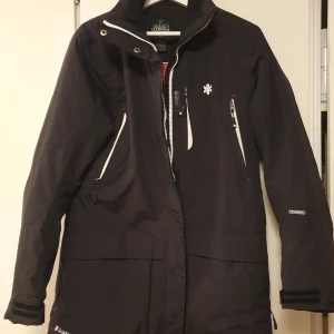 Vinterjacka - Fodrad vinterparkas. 86 cm lång. Ej använd. Många fickor. Huva. Vind och vattentät