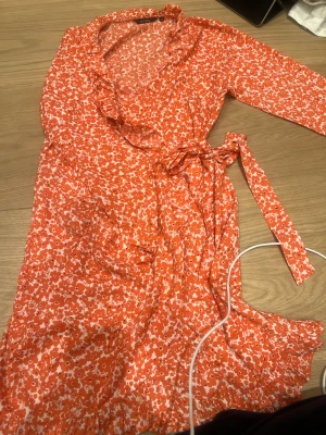 Omlott klänning - Säljer denna fina blommiga omlott klänning från Ally Bell. Köparen står för frakten 