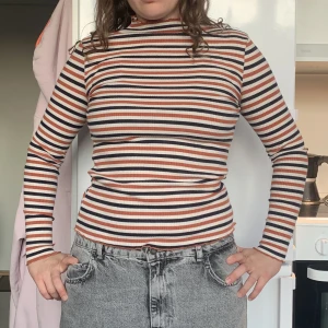Långärmad tröja  - Randig långärmad tröja i ribbat material. Mörkblå, varm orange och vit, har inte använt på länge. Köpte den för 500kr.