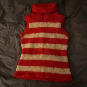Stickad väst - Röd/vit randig stickad väst. Mer creme färgad än vit. 