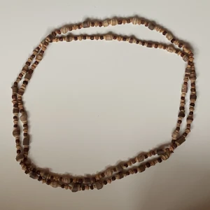 Trä halsband. - Fint hippie halsband, i trä och långt så man kan vika det dubbelt. Hör gärna av dig vid frågor !!