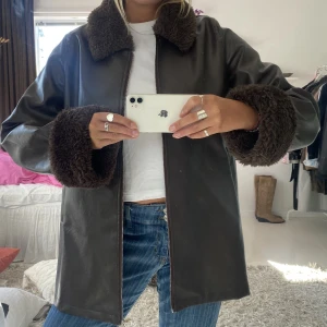 Fake skinnjacka med päls  - Brun tunn fake skinnjacka med päls vid händerna och kragen 