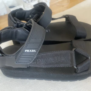 PRADA sporty nylon strap sandals - Helt oanvända Prada-sandaler. Enbart provade inomhus. Beställda från Prada Europe hemsida så orderbekräftelse/kvitto finns på mail. Säljer pga för små efter graviditet. Storlek 38. Nypris 5000.