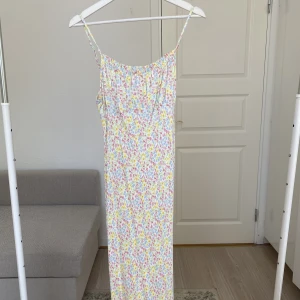 Blommig midi klänning - Blommig Midi klänning från Primark i storlek 44. Tunnt silky material med justerbara band.