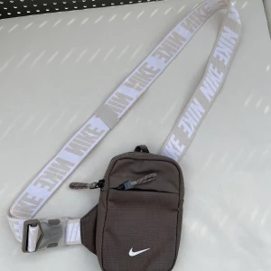 Nike axelväska - Säljer min Nike axelväska, använd ett fåtal par gånger. Skicket är i princip helt nytt 9/10 Säljes pga att den inte längre kommer till användning. Tveka inte att skriva om du har ytterligare funderingar🫵💫
