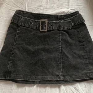 Svart kort kjol - En super gullig kjol i storlek 36! Använd 2-3 gånger och har absolut inga fel! Den har ett bälte som man kan justera och även en dragkedja där bak😊