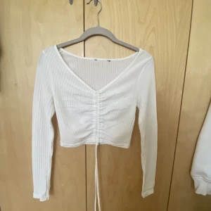 Ribbad långärmad - Snygg vit croppad långärmad topp med ribbad material, köparen betalar för frakt