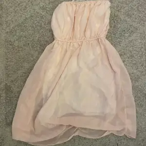 En rosa jätte gullig klänning med vita volanger på och den är stretchig och köparen står för frakten och har använt den typ 4 gånger så den är i bra skick 
