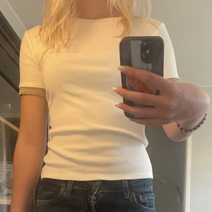 Vit tröja  - Säljer denna snygga vita tröjan från zara med guldiga detaljer på armarna🤩