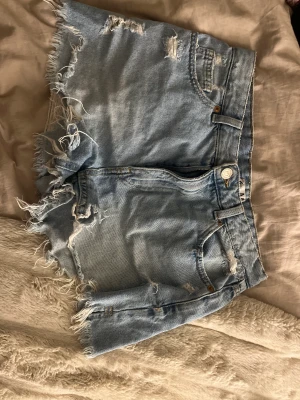 Jeans shorts - Jag säljer ett par jeans shorts som är i storlek M, dom har slitningar och är ljusblå skit snygga på.